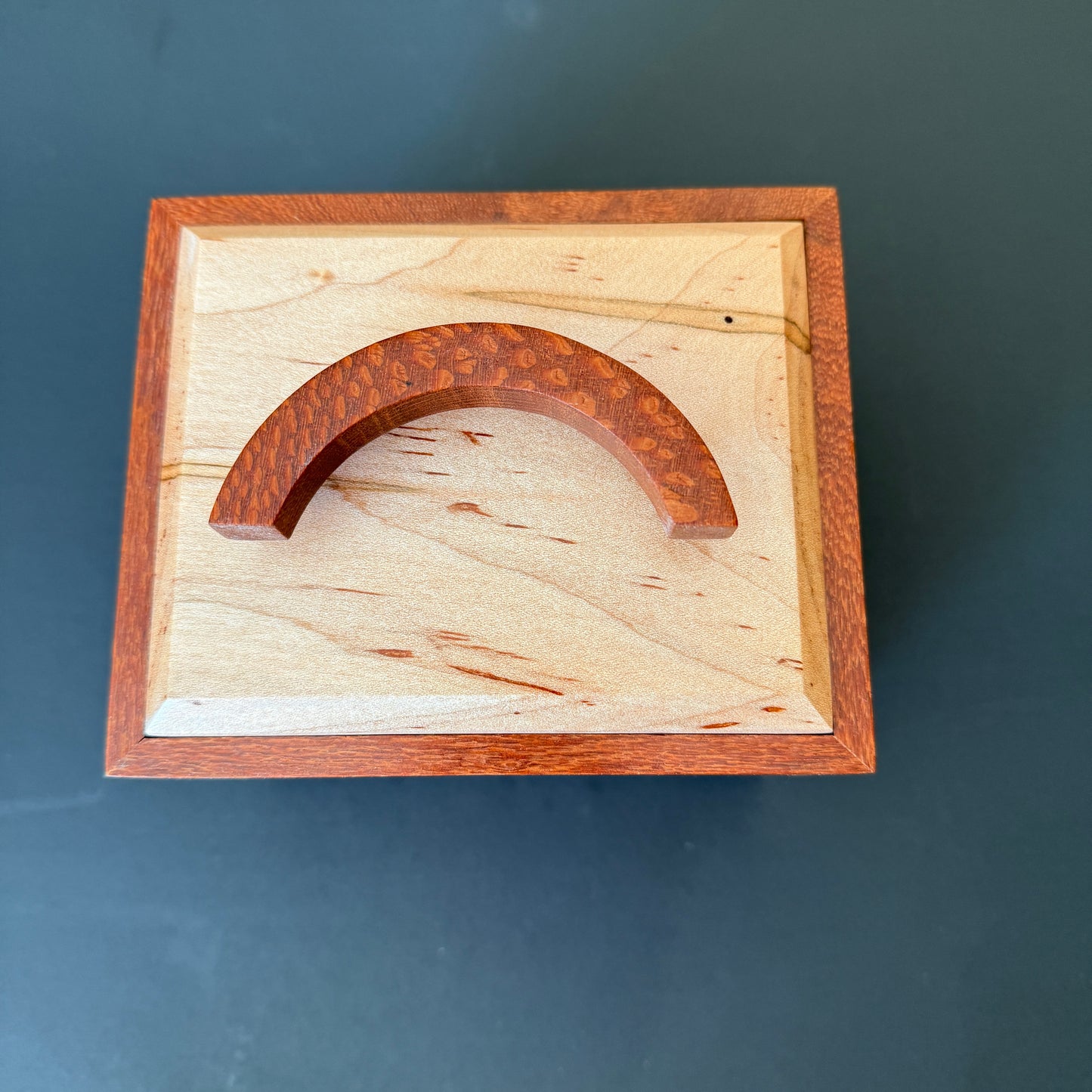 Beautifully crafted keepsake box. Top view. The handle is a crescent moon shape leopard wood standing in the middle of the lid. It measures 6 x5 and 6 1/2 inches tall. For additional help please reach out to me.