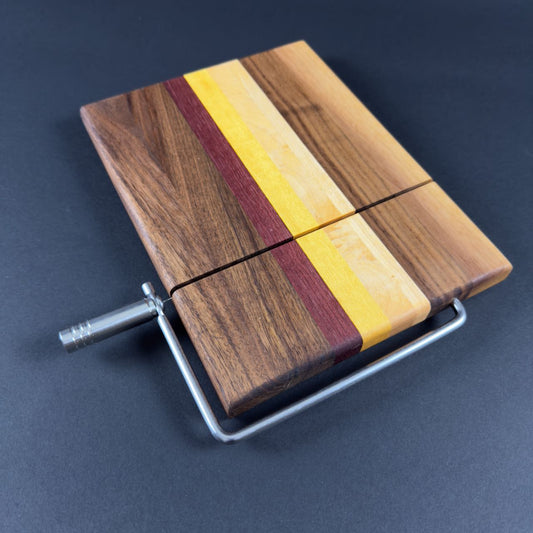 Stunning multicolored solid natural hardwood cheese slicing board made for a combination of walnut, purple heart, yellow heart and maple, top view.