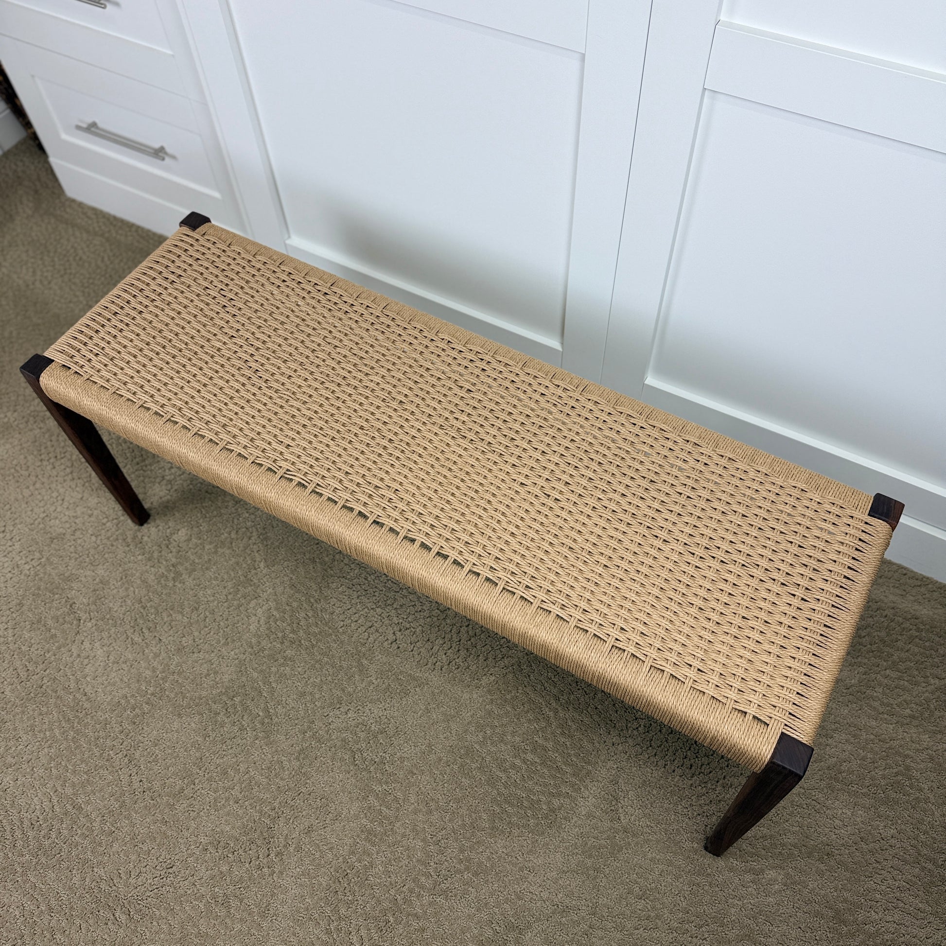 Top view of a woven seating area wooden bench.