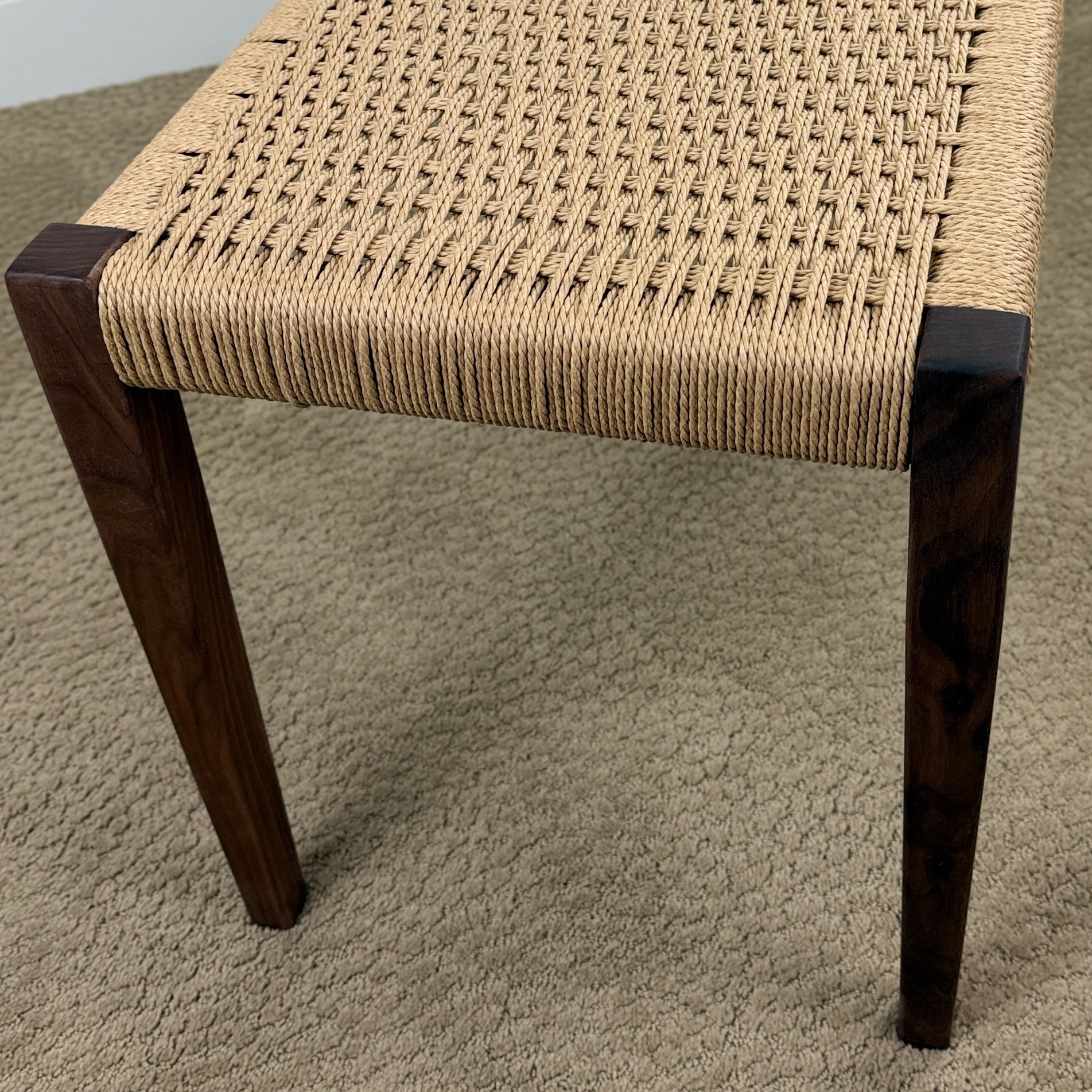 End view of tapered legs on a Danish cord weave bench.