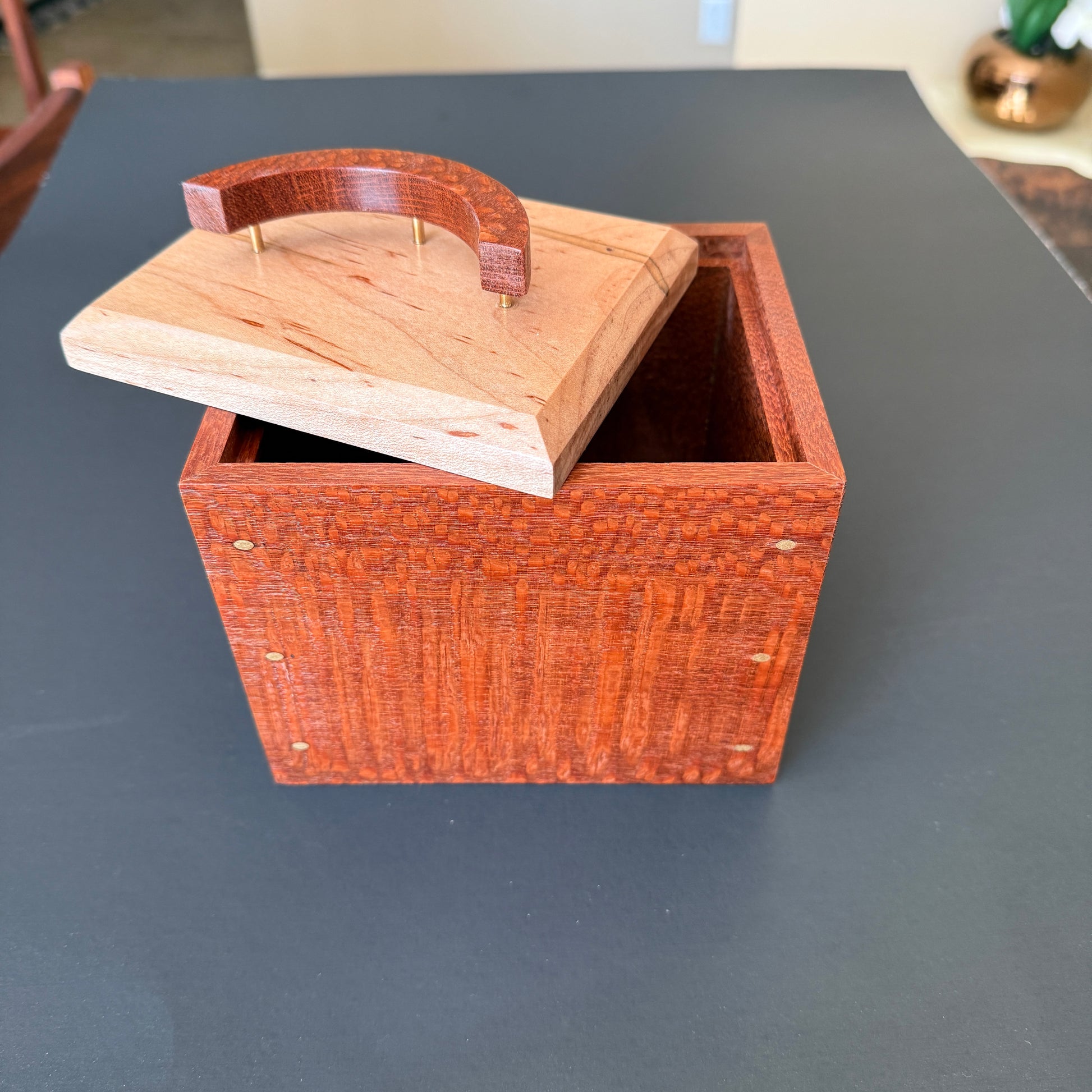 Beautifully crafted keepsake box with the lid sitting off to one sdie of the top.. The body is make of leopard wood with an ambrosia maple top. The handle is a crescent moon shape standing on three thin brass posts. For additional help please reach out to me.